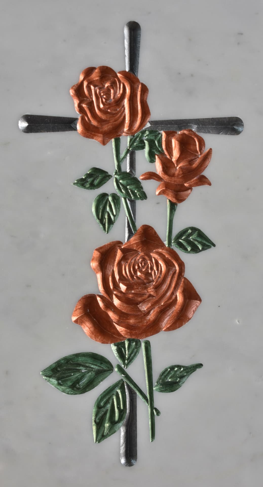 Croce con rose ramate e foglie verdi incise su marmo