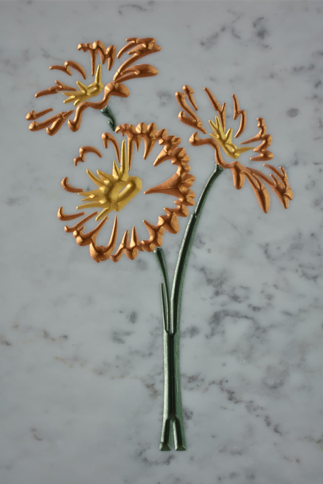 Composizione floreale ramata e dorata su marmo
