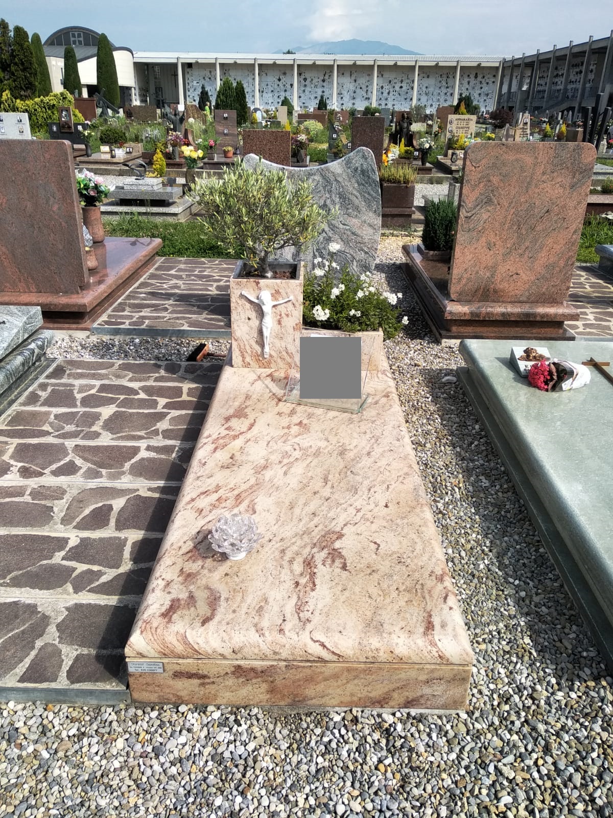 Tomba in marmo rosa venato con stele sagomata e crocifisso