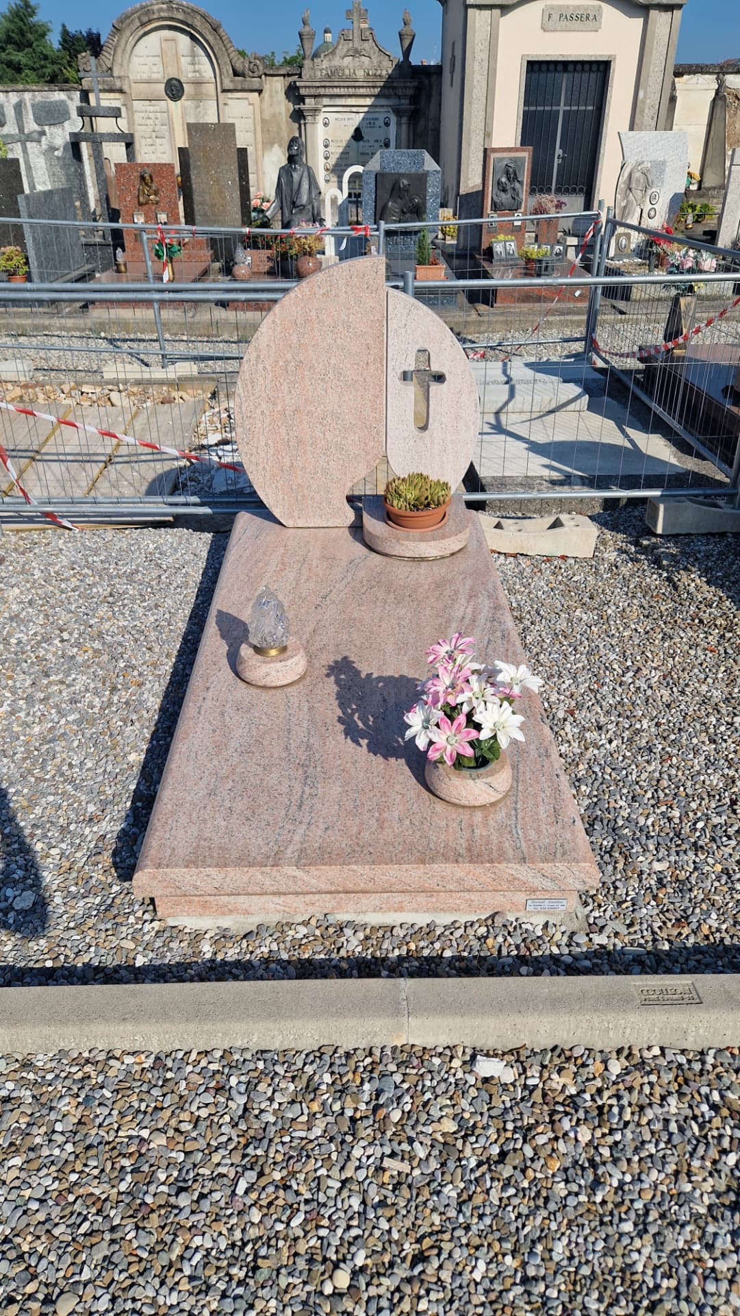 Tomba in granito rosa con stele circolare e croce in rilievo