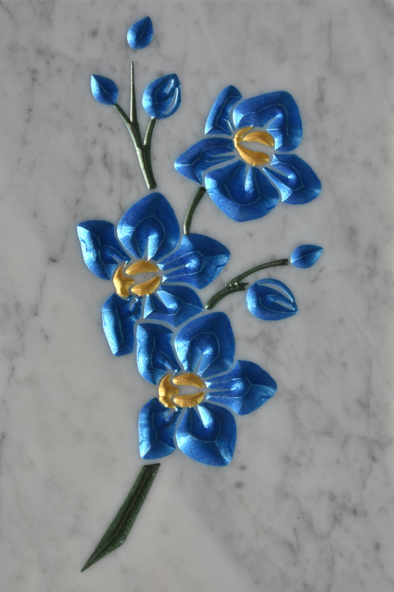 Orchidee azzurre e dorate incise su marmo