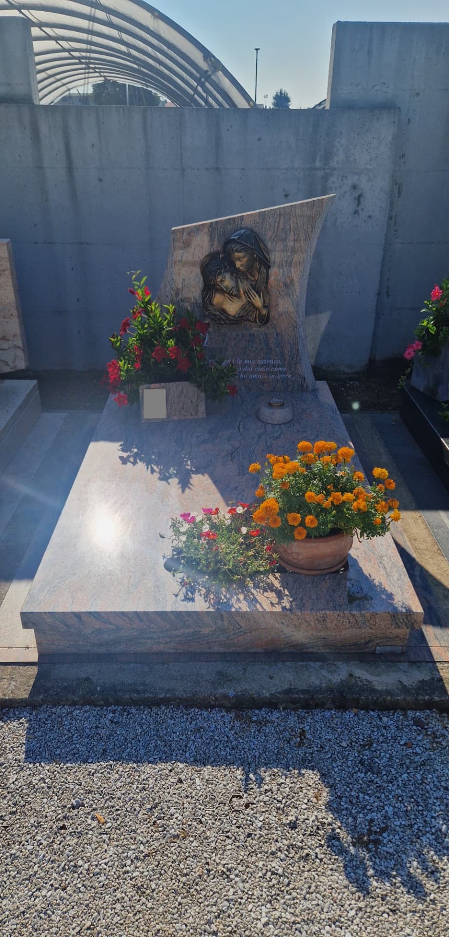 Tomba in granito rosa venato con stele a vela e bassorilievo bronzeo della Pietà