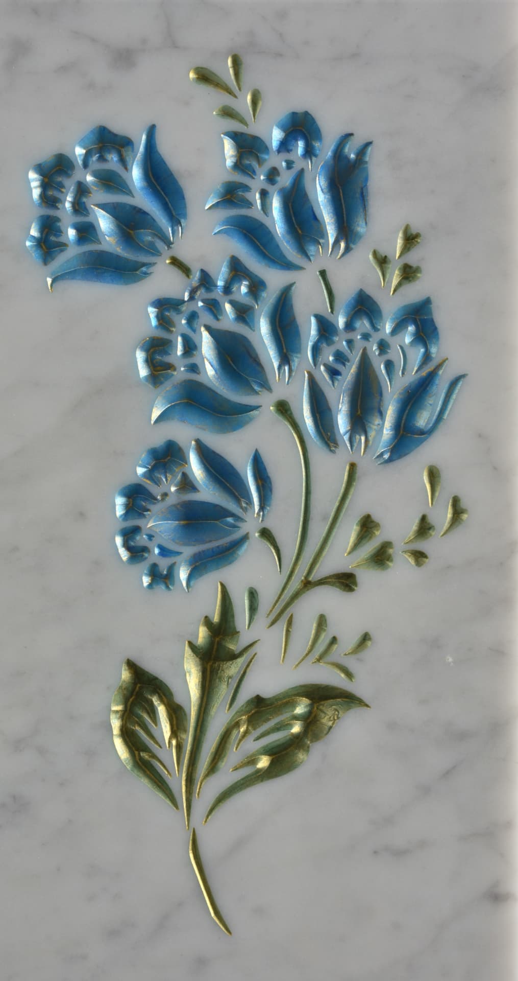 Fiori azzurri e ramati incisi su marmo