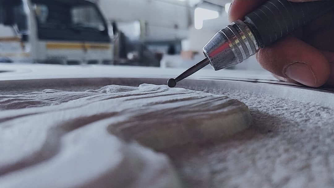 Artigiano al lavoro sulla lucidatura di una lastra di granito