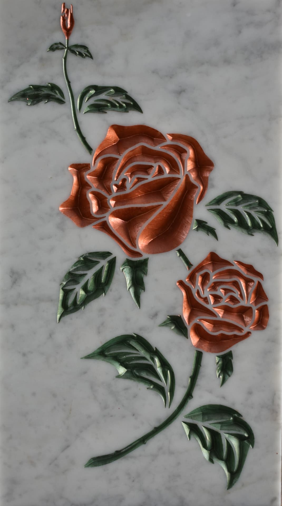 Due rose incise su lastra di marmo di Carrara