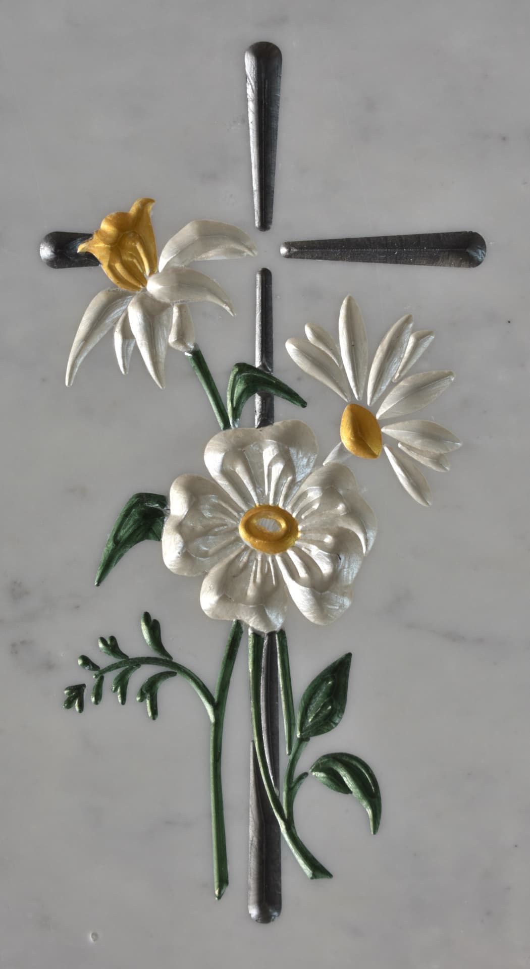 Croce con margherite bianche e dorate incise su marmo